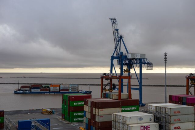 Containere de marfă încărcate într-un port, pregătite pentru transport maritim